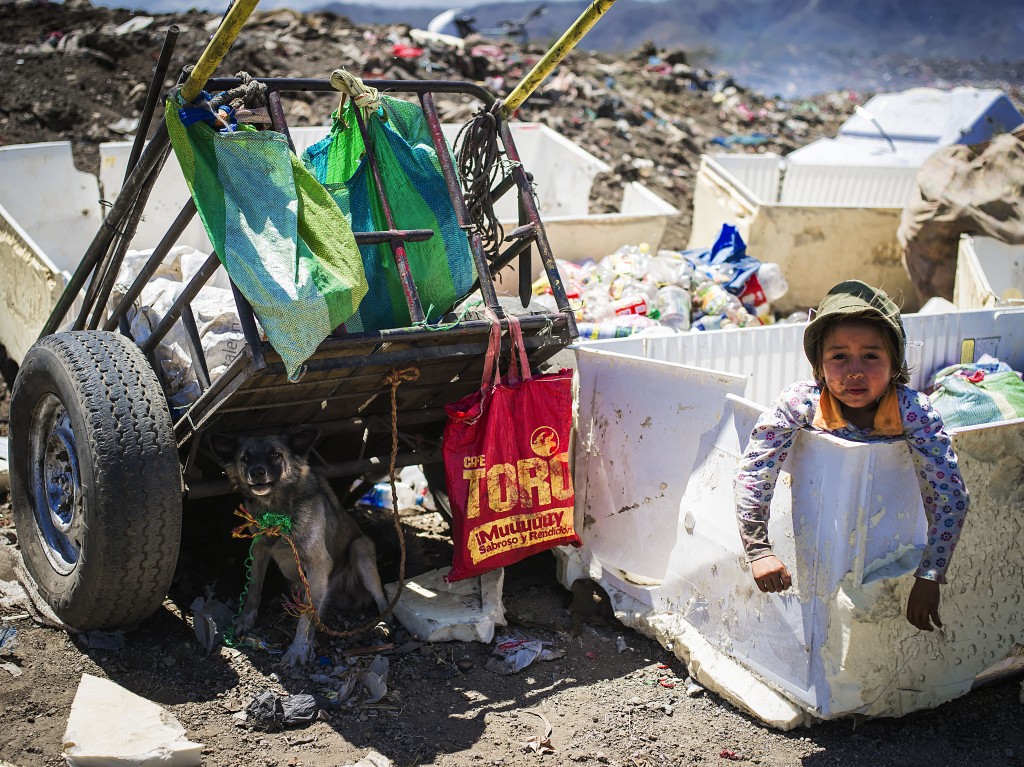 A little girl plays and waits for her mother while she sorts garbage inside Nueva Vida trash dump. Many children are raised in dump sites and that becomes their job from childhood. Ciudad Sandino, Nicaragua. Photo by: Timothy Bouldry, 2015. 